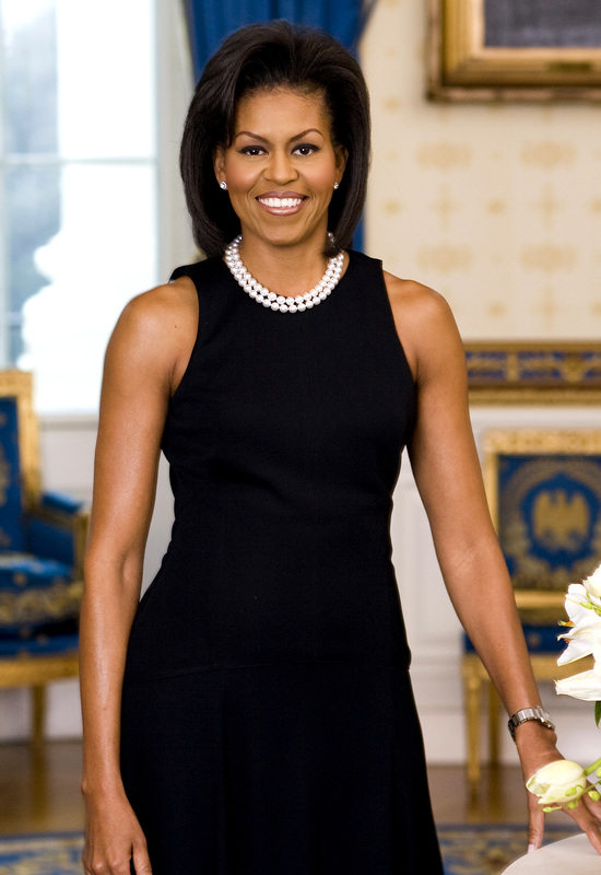 Michelle Obama standing in a black dress.